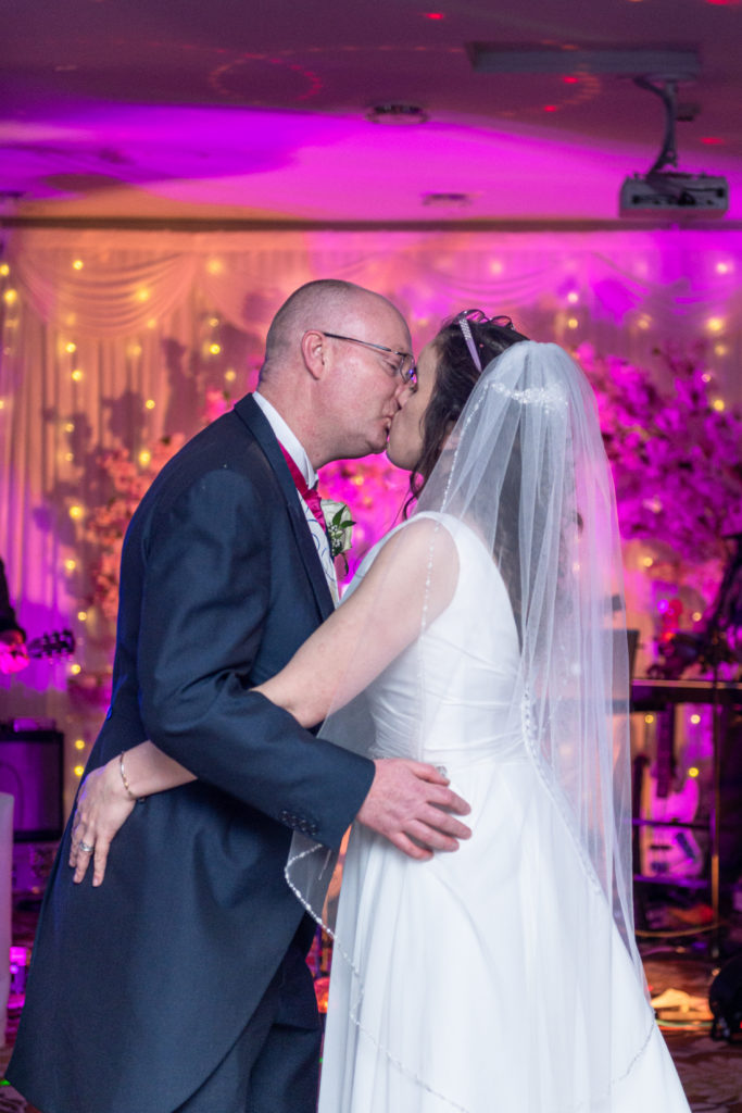 Emotional hug shared between bride and wedding guest during candid wedding moment