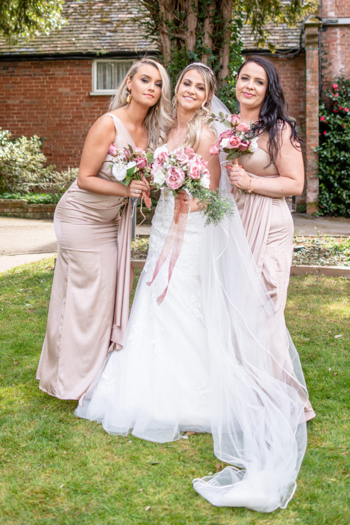 Jady in her wedding dress holding bouquet in the gardens of Charlecote Pheasant Hotel