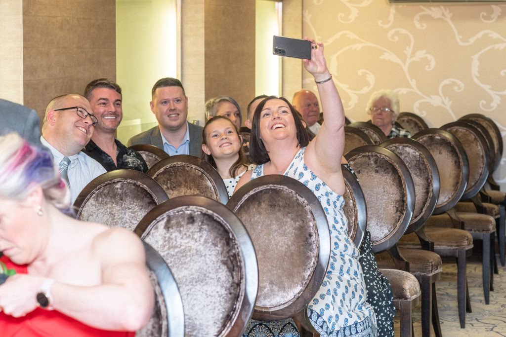 Guests taking a selfie at colourful wedding ceremony