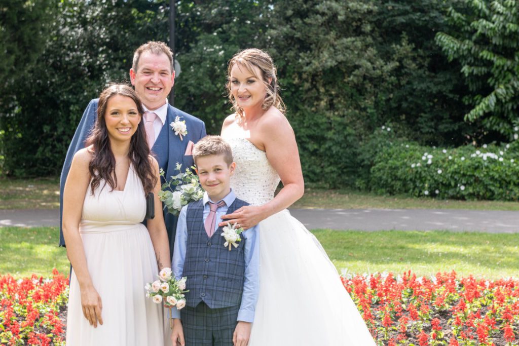 Cally, Paul, and their child smiling together outside the registry office