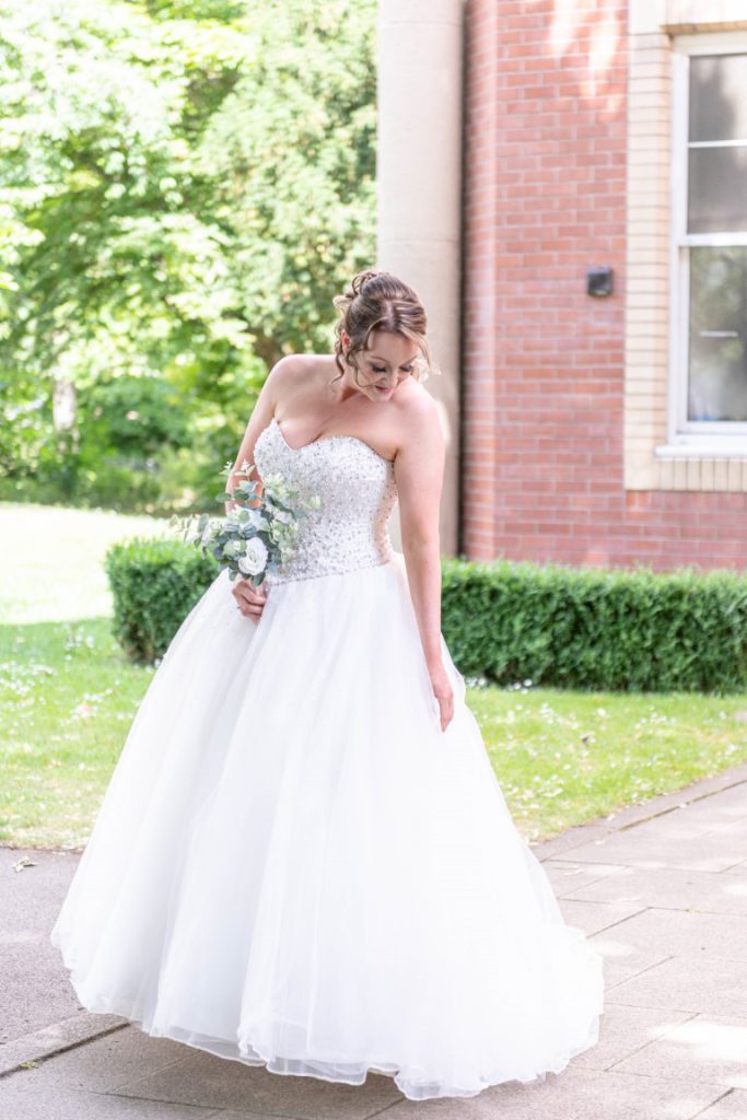 Cally smiling in her flowing princess-style wedding dress