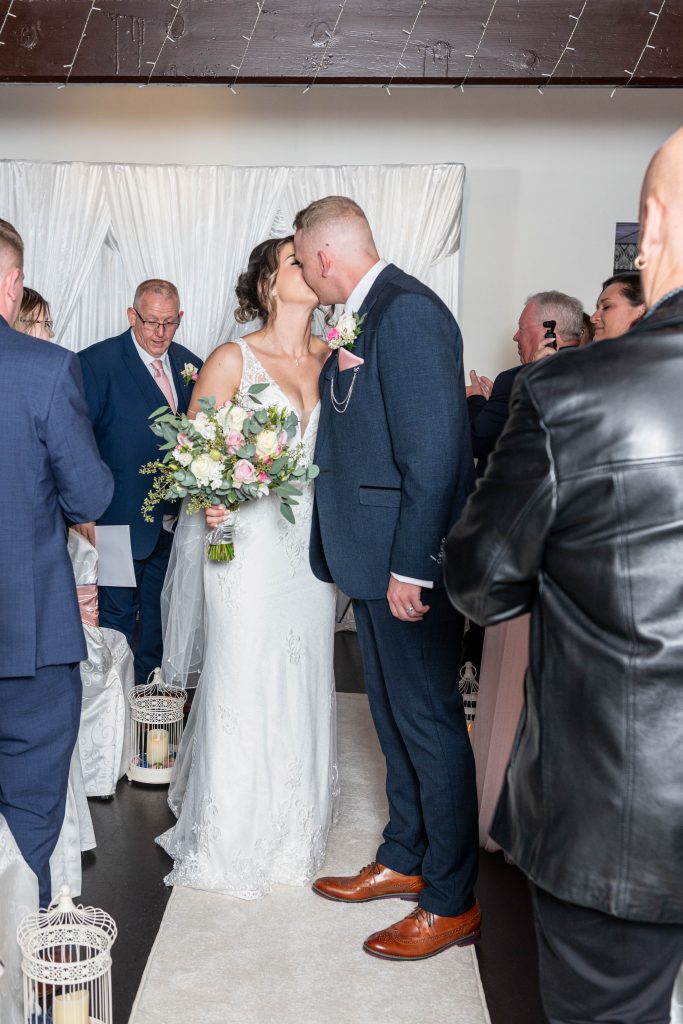 Caeri and Andy smiling at each other during their first kiss