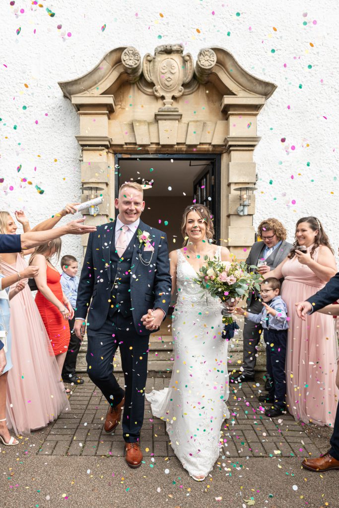 Confetti shower over Caeri and Andy as they exit the ceremony