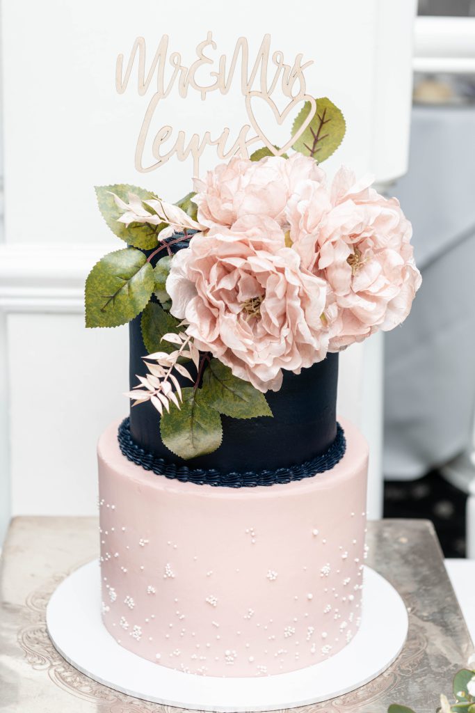 Rose blush and blue tiered wedding cake with florals on top
