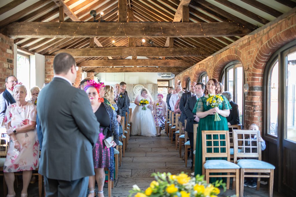 Sarah walking down the aisle with her mum at Dodmoor House
