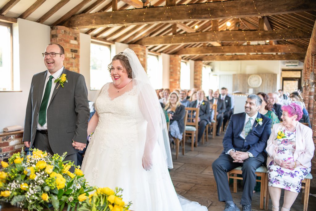 Sarah and James smiling during their wedding ceremony