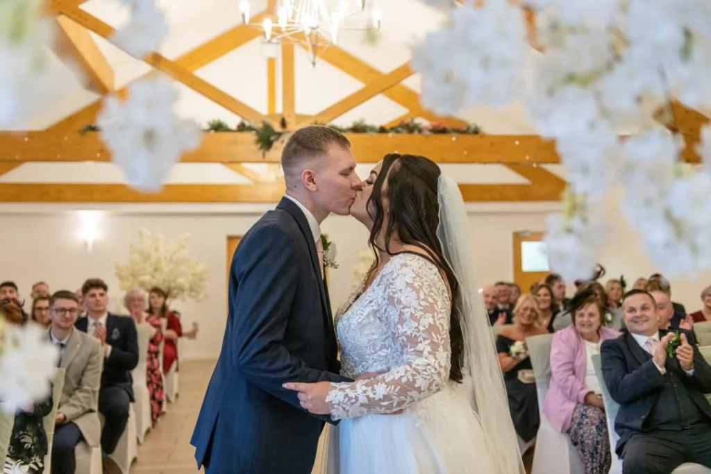 Leah and Ryan share a joyful first kiss after their ceremony during their winter wedding at Draycote Hotel