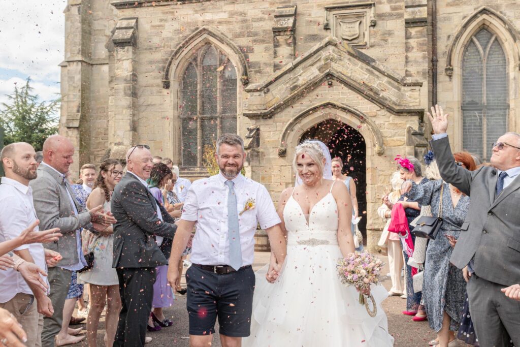 Guests throwing confetti during a fun moment in the couple’s Stress-Free Wedding Timeline