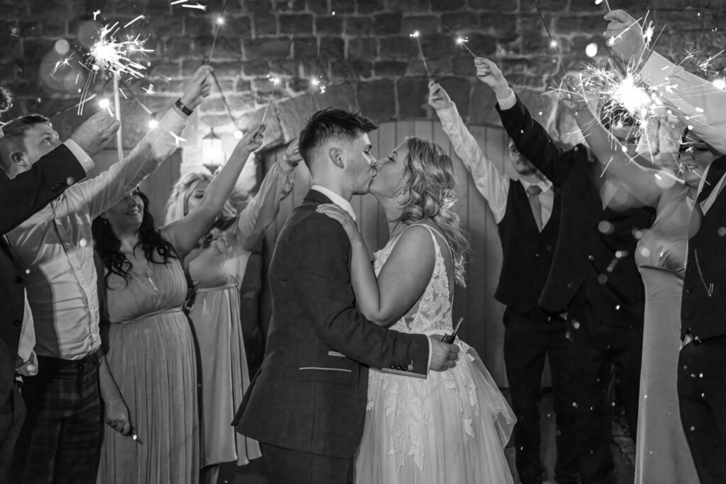 Bride and groom kiss under an arch of sparklers – classic sparkler wedding photo