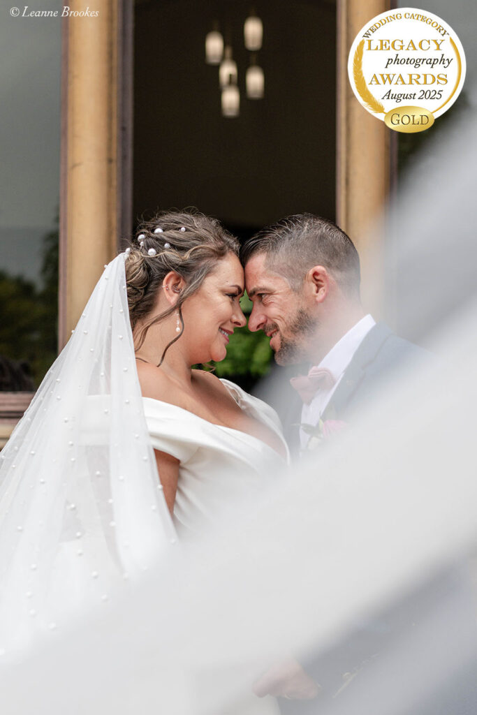 Wedding Photography Portfolio – close-up of newlyweds smiling with veil detail framing their faces