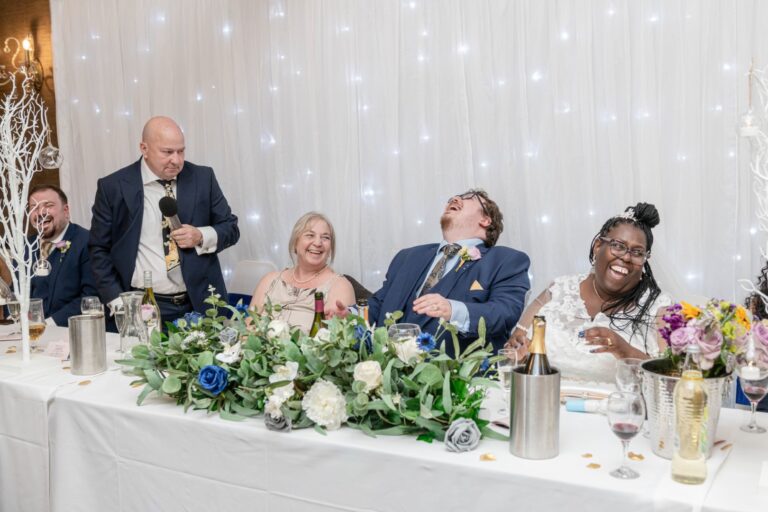 Unposed wedding reception photo of guests laughing – showing the magic of unscripted wedding moments