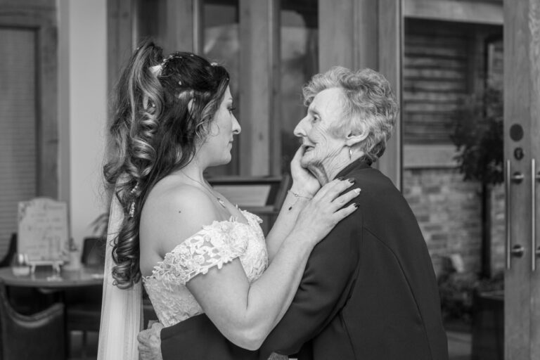 Heartfelt candid wedding photo of bride hugging a loved one – the emotional magic of documentary wedding photography